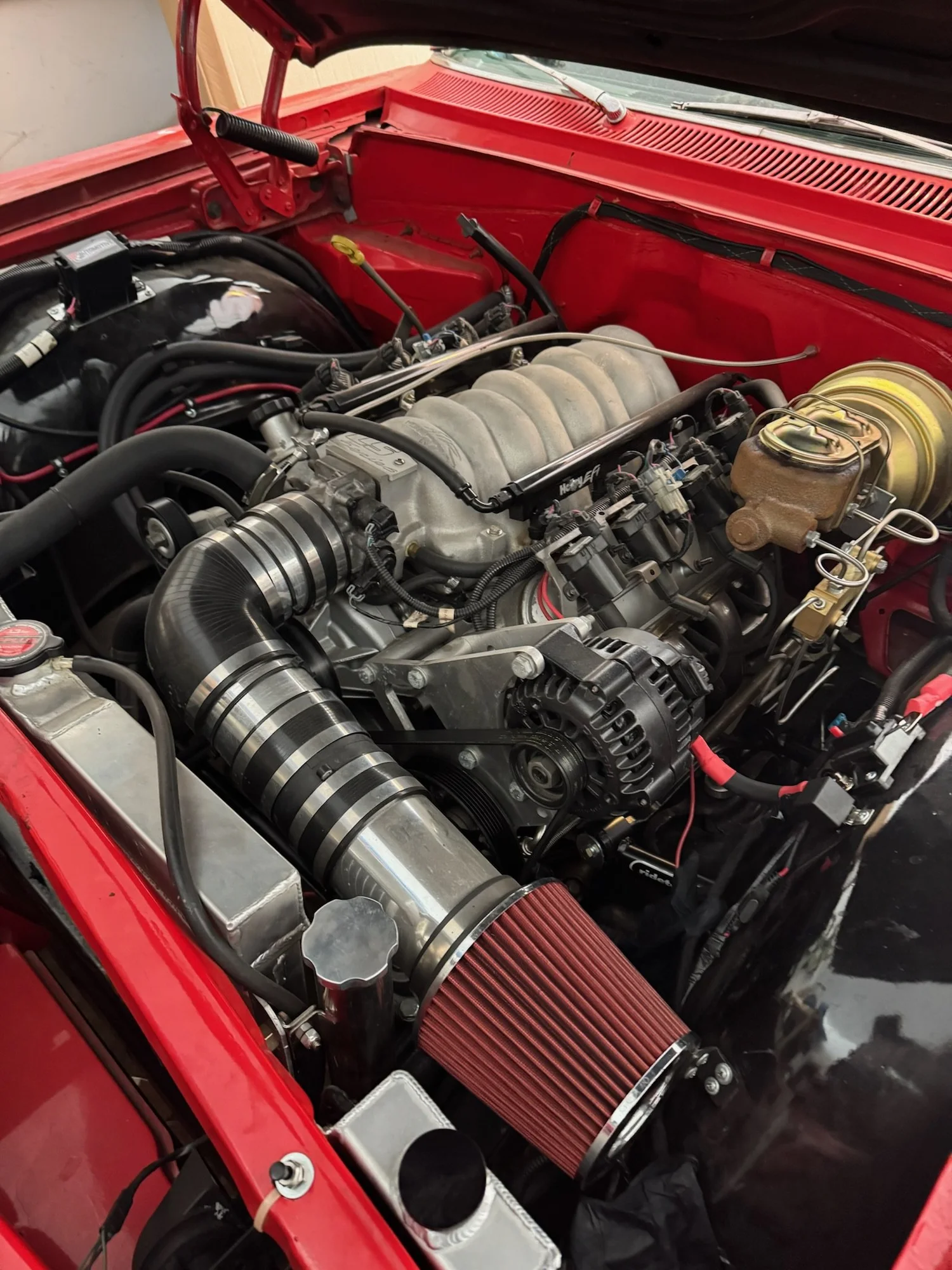 LS engine swap in a red engine bay, with Holley EFI, polished intake tubing and an aluminum radiator